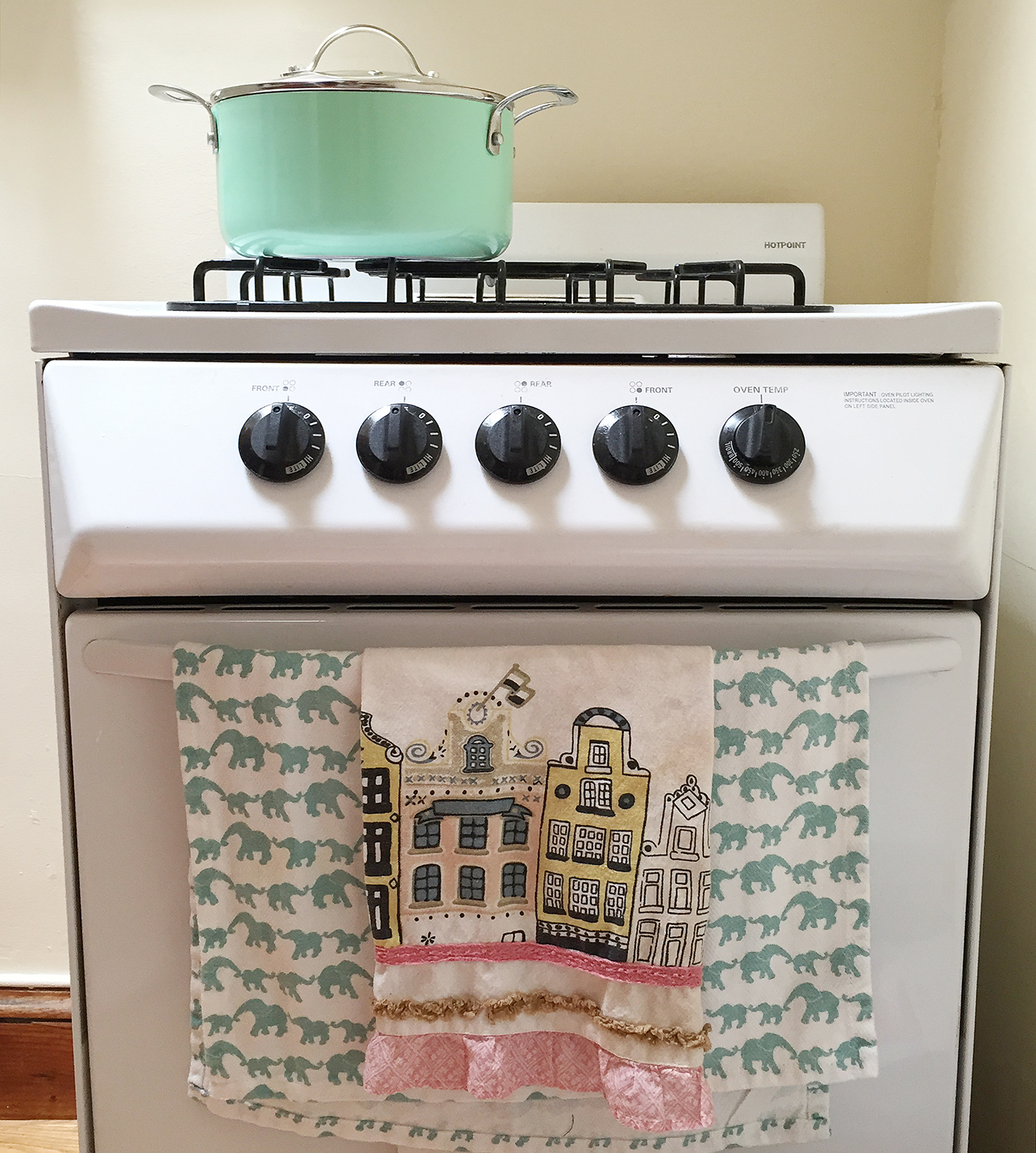 Small stove with turquoise pot and elephant print dish towels