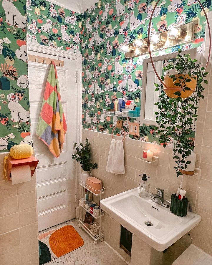 Bold and bright green bathroom in studio apartment decorated with bold maximalist printfresh peel and stick NuWallpaper for a fun accent piece in a small space