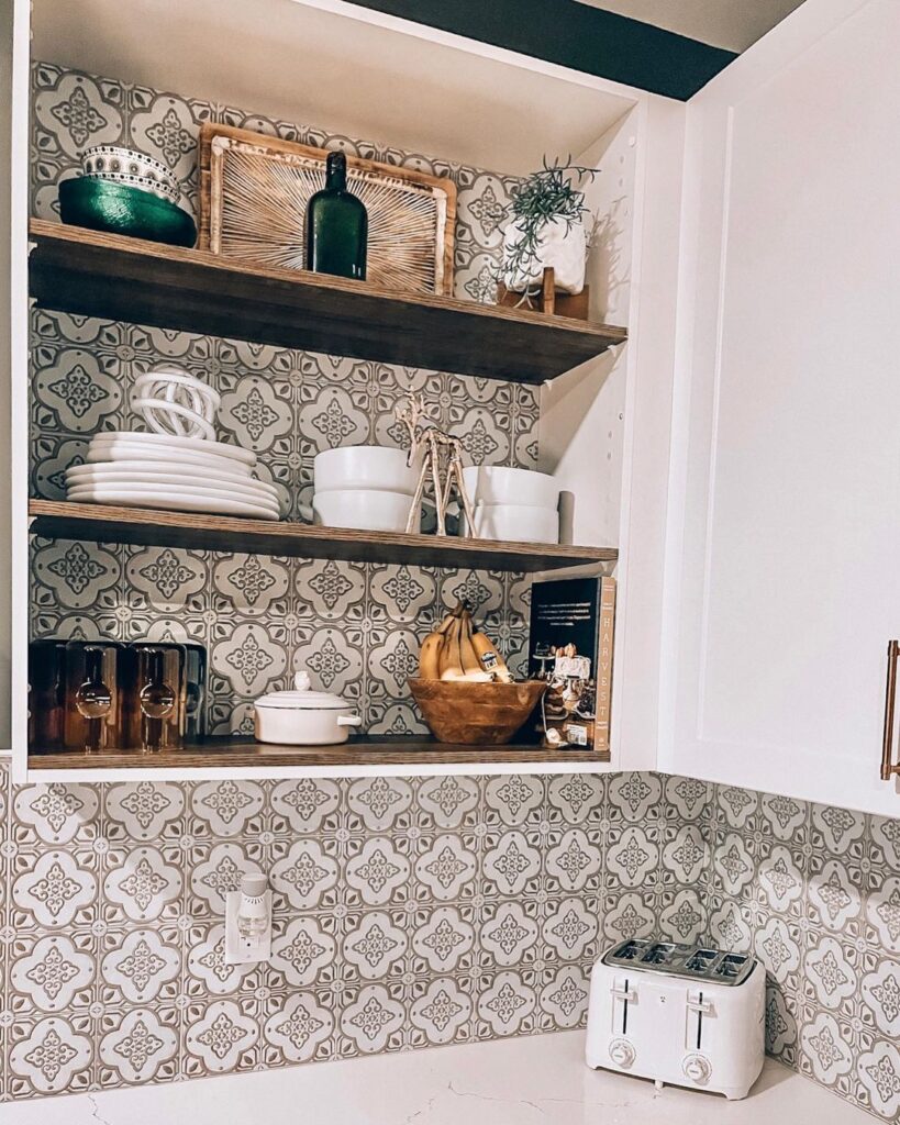 Open faced shelves in the kitchen with peel and stick backsplash tiles installed in taupe coloring.