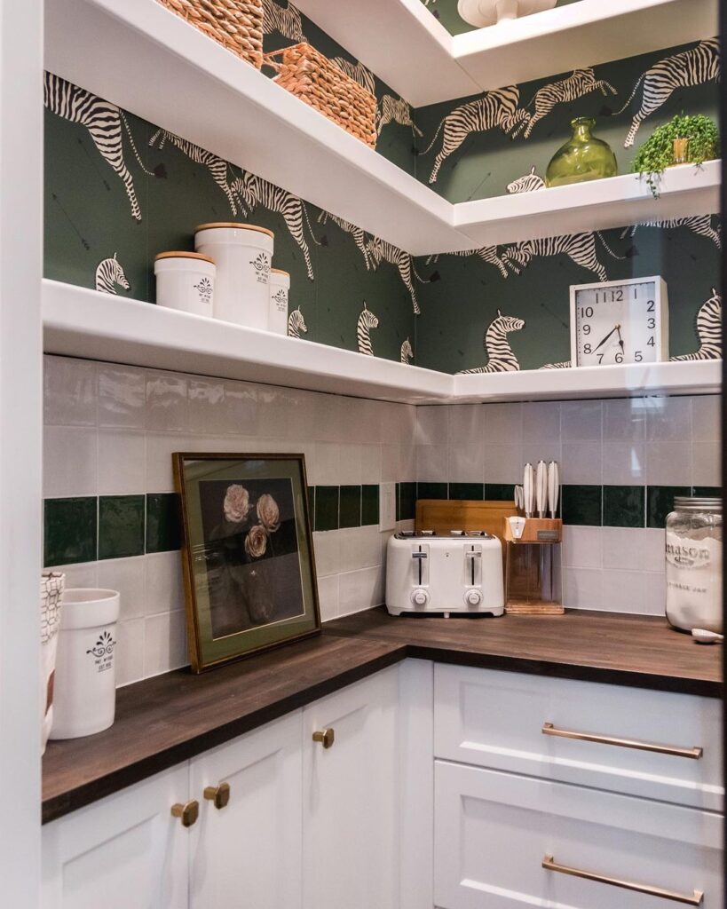 Green Scalamandre peel and stick NuWallpaper features a stampede of zebras in this walk-in pantry space